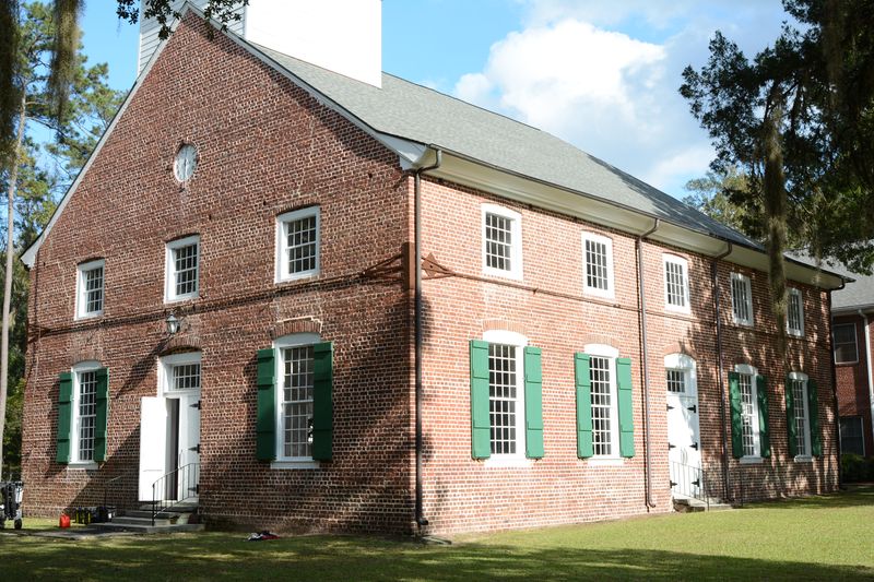 The church from an angle, showing the front gable and the long side with green shutters